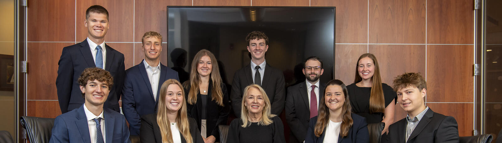 photo of Dean's Student Advisory Board sitting and standing next to a conference table