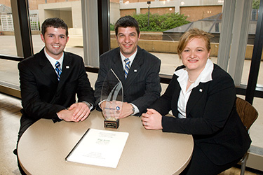 photo of three business students with an award