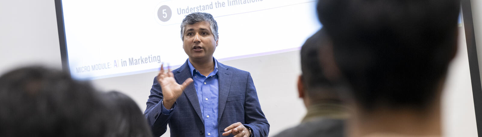 photo of a professor speaking to students in a classroom